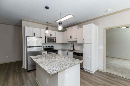a kitchen with white cabinets and a granite counter top at Westmount at Ashwood, Atlanta, Georgia
