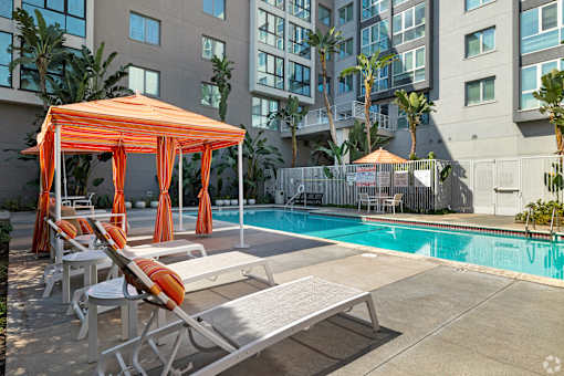 A pool area with sun loungers and a canopy.
