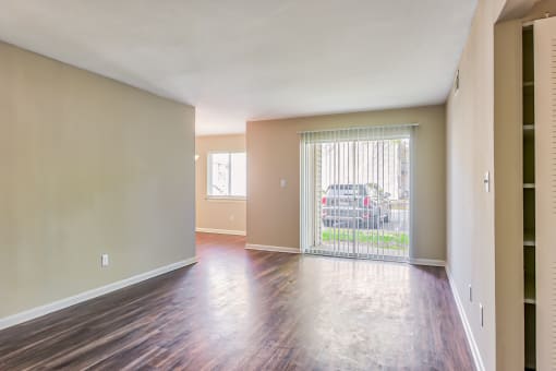 a bedroom with a sliding glass door and hardwood floors