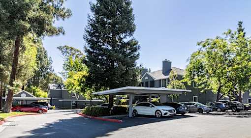 A parking lot with cars and a building in the background.