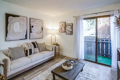 A living room with a couch, coffee table, and pictures on the wall.