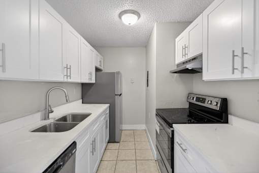 A kitchen with white cabinets and black appliances.