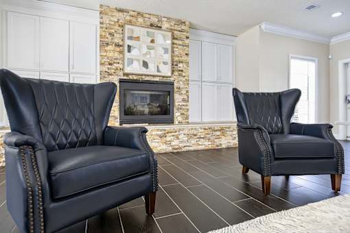Modern lounge with fireplace and wingback chairs at The Ivy at Gatehouse Apartments, Orlando, Florida