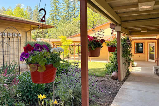 A garden with a variety of flowers in a red pot.