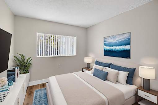 A bedroom with a large bed and a painting of a wave on the wall.