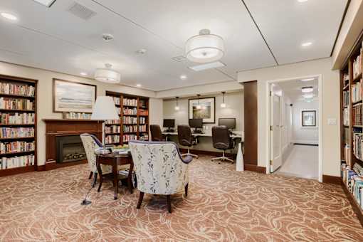 A room with a carpeted floor and a fireplace.