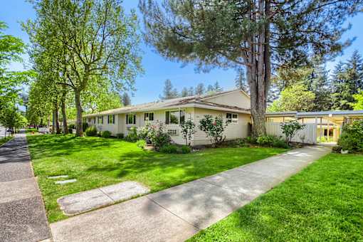 A house with a white fence and a green lawn.