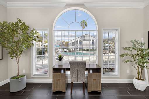 Office workspace with arched window and pool view at The Ivy at Gatehouse Apartments, Florida