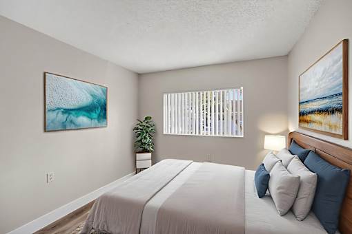 A bedroom with a large bed and two framed pictures on the wall.