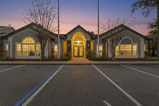 Illuminated clubhouse building at twilight at The Ivy at Gatehouse Apartments, Florida, 32807