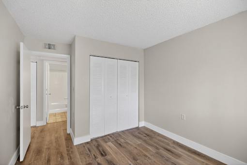 A room with a white door and a white closet.