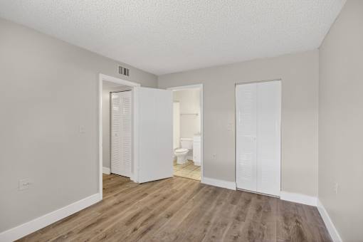 A room with a toilet, sink, and closet in it.