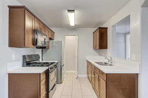 A kitchen with brown cabinets and white countertops.