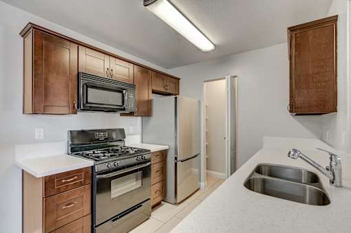 A kitchen with a stove, oven, microwave, and refrigerator.