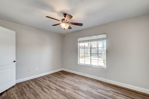 A room with a ceiling fan and a window.