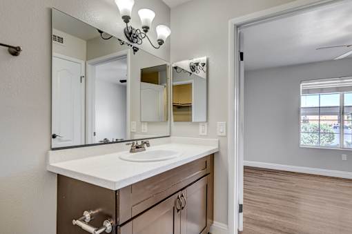 A bathroom with a sink, mirror, and light fixture.
