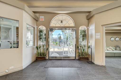 A hallway with a glass door leading to a balcony.
