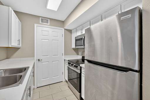 Kitchen with Stainless steel refrigerator at Mer Soleil Apartments, Naples, Florida