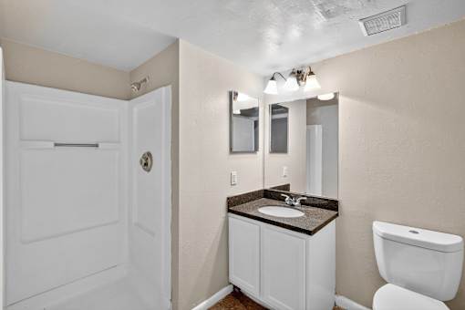 A bathroom with a white toilet, sink, and medicine cabinet.