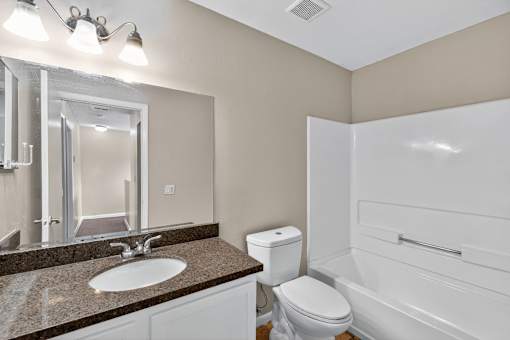A bathroom with a sink, toilet, and bathtub.