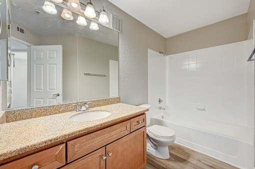 Bathroom with granite countertop and tub shower combo at Borgata Condominiums Apartments, Las Vegas, Nevada