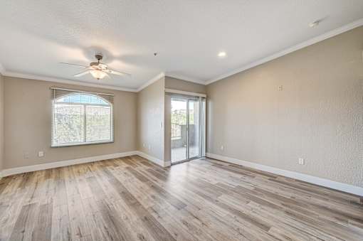 Open living room with patio doors and ceiling fan at Borgata Condominiums Apartments, Las Vegas, 89103