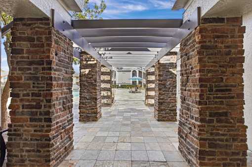 Covered walkway with brick columns and pergola at The Ivy at Gatehouse Apartments, Orlando, Florida