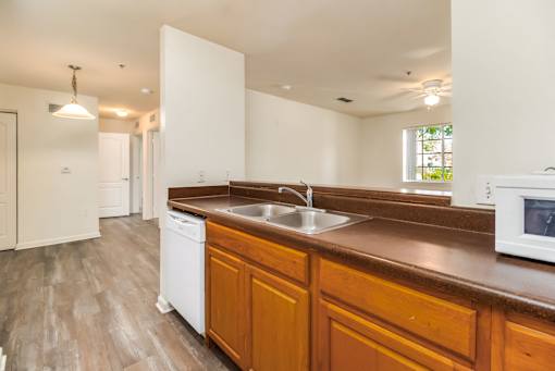 A kitchen with wooden cabinets and a white dishwasher.