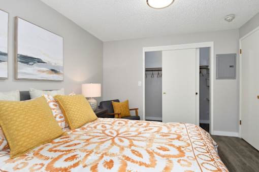A bedroom with a bed, two lamps, and a painting on the wall.