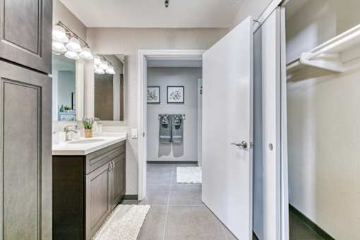 A bathroom with a sink, mirror, and a white door.
