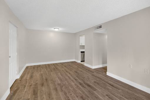 A room with wooden flooring and white walls.