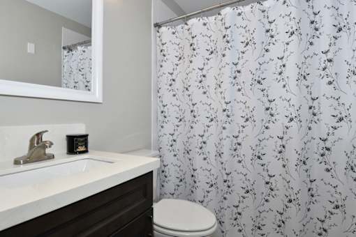 A white sink with a gold faucet and a toilet in a bathroom.