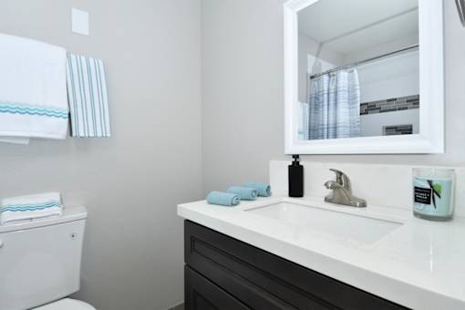 A white toilet sits next to a sink in a bathroom.