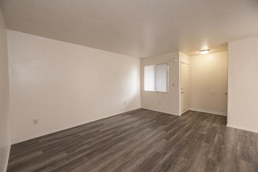 A room with wooden flooring and white walls.