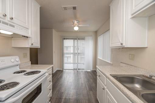 A kitchen with white cabinets and a stove top oven.
