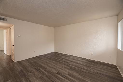 A room with wooden flooring and white walls.
