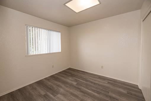 A room with a window and wooden flooring.