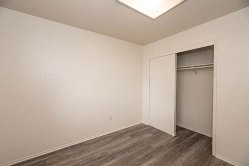 A room with a grey floor and a white wall with a door.