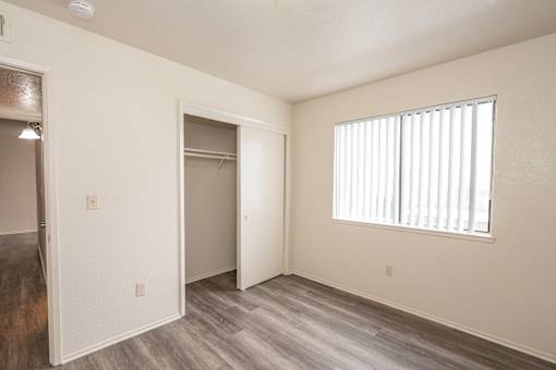 A room with a sliding door and a window with blinds.