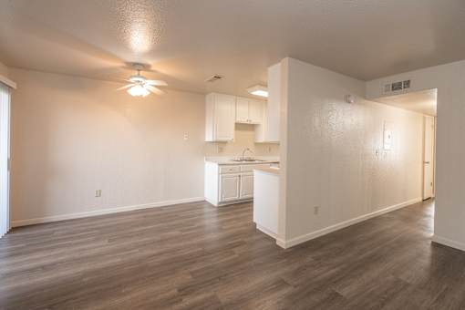 A room with a kitchenette and a ceiling fan.