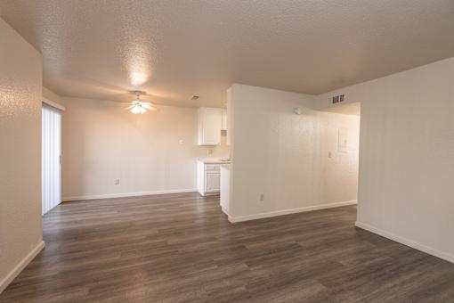 A large empty room with wooden floors and white walls.