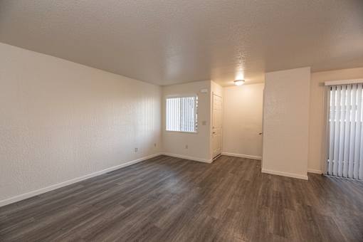 A room with wooden flooring and white walls.