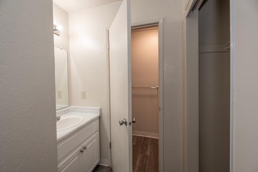 A white bathroom with a sink and a door.