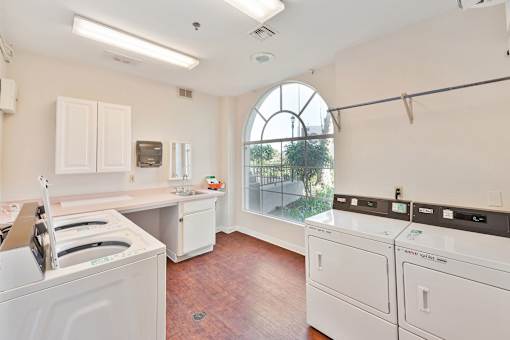 a laundry room with white appliances and a large arched window at Azure Point at Encinitas, Encinitas, 92024