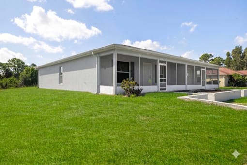 A modern house with a white exterior and a large lawn in front.
