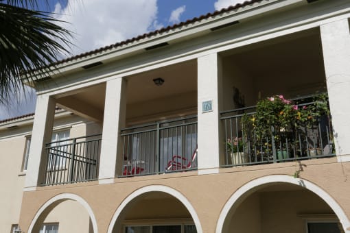 the facade of a building with balconies and plants