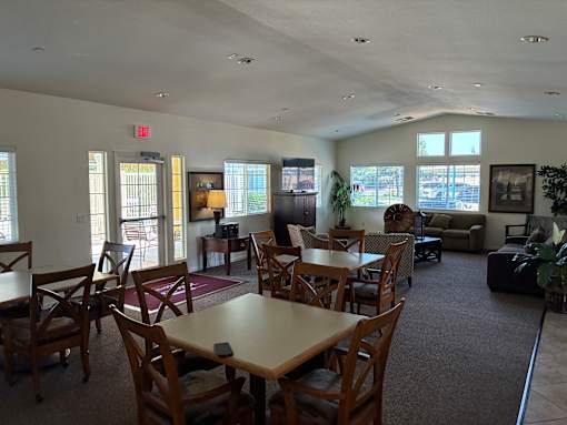 A large room with tables and chairs and a couch.