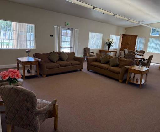 A living room with brown couches and a chair with a pink flower on it.