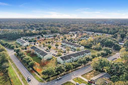 A bird's eye view of a residential area with multiple houses and a road.