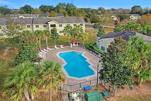 A pool surrounded by a fence and trees.
